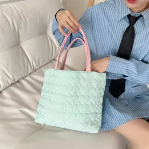 Detailansicht einer weichen, gesteppten Herz-Tasche in Minzgrün und Rosa gehalten