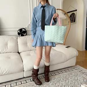 Detaillierte Ansicht der mintgrünen Herz-Stepptasche von Modell im Alltag gehalten