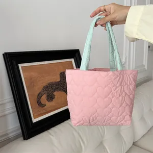 Detail der rosa gesteppten Herz-Tragetasche mit minzgrünen Griffen in Lifestyle-Umgebung