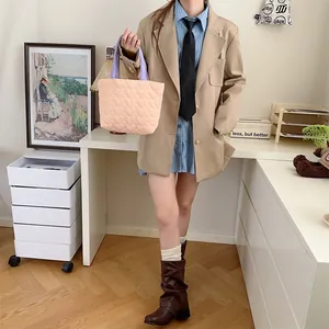 Weiche gesteppte Tragetasche mit Herzmuster in Rosa, gehalten von einem Model im Zimmer.