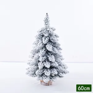 Detailed view of a 60cm snow-flocked Christmas tree with a natural wood base