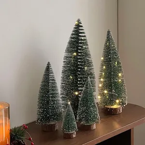 Detailansicht verschiedener Mini-Weihnachtsbäume mit Schneeeffekt und warmen LEDs