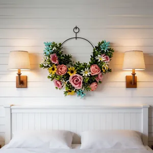 Elegant artificial flower wreath with pink roses and daisies on a bedroom wall
