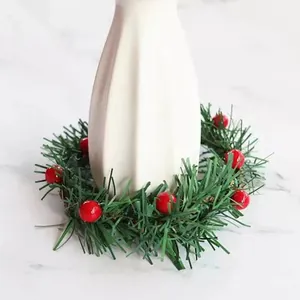 Miniature Christmas wreath candle ring with green pine needles and red berry table decor