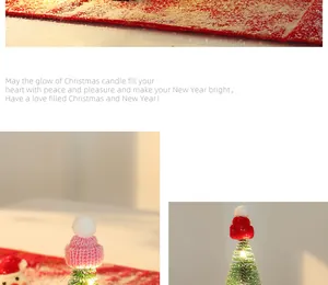 Detail eines kleinen beflockten Weihnachtsbaums mit rosa Strickmütze und LED