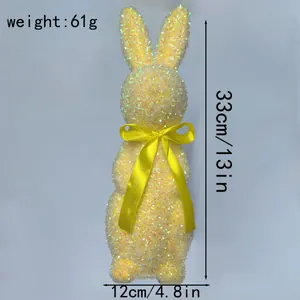 Detail view of a yellow glittery Easter bunny figurine with size measurements