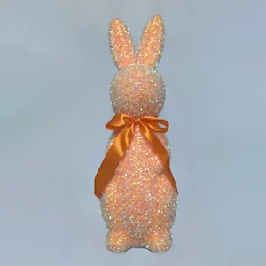 Detail of peach glitter Easter bunny figurine with an orange satin ribbon bow