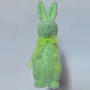 Detailed view of a decorative green glitter Easter bunny figurine with matching organza bow