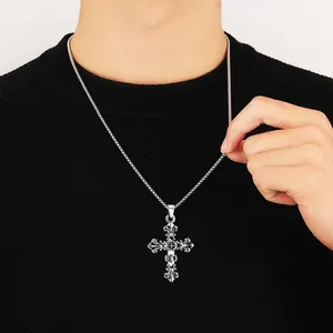 Close-up of vintage gothic cross pendant necklace on male model wearing black sweater