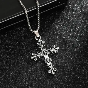 Detailed view of the intricate gothic fleur-de-lis carvings on the silver cross pendant.