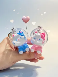 Close-up of cute astronaut cat keychains in pink and blue variants
