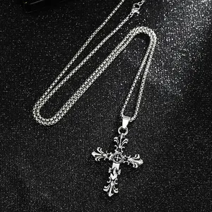 Close-up of a vintage punk style titanium steel cross pendant necklace on a glittery background
