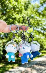 Detailed view of cute space themed cat keychains with transparent spherical covers