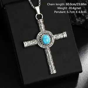 Macro detail of vintage titanium steel cross pendant with turquoise stone centerpiece