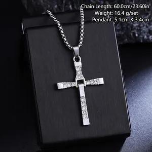 Macro detail of a titanium steel cross pendant necklace with inlaid rhinestones.