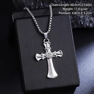Detailed view of a vintage silver cross pendant with crown detail on a black box