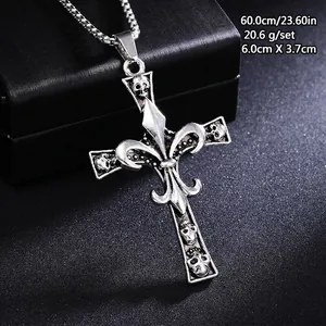 Detail of vintage gothic cross pendant necklace with skulls and fleur-de-lis motifs