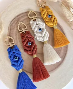 Handmade bohemian macrame keychains with evil eye beads and heart-shaped clasps.