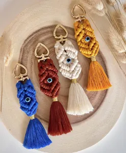 Detail of four colorful handmade macrame keychains with tassels and evil eye beads