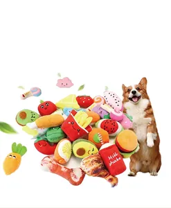 Dettaglio di vari giocattoli di peluche per cani a forma di cibo con un cane Corgi.