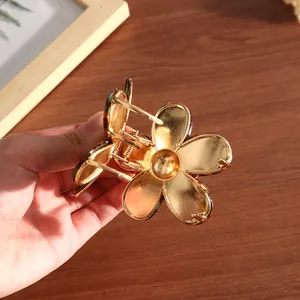 Detaillierte Makroansicht der kleinen goldenen Blumen-Haarklammer mit Acetat-Veredelung