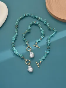 Detailed view of turquoise stone jewelry set with elegant pearl pendants and gold OT clasps