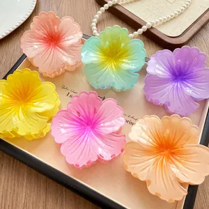 Detail of six vibrant gradient flower hair claw clips arranged on a display tray