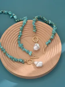 Detailed shot of turquoise bead necklace and bracelet set with white baroque pearls