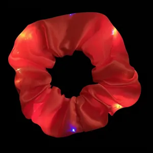 Detailed shot of red LED glowing hair scrunchie featuring multiple light modes for parties
