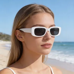 Close-up of model wearing retro white rectangular small frame sunglasses at the sunny beach