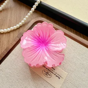 Close-up detail of a fashion pink gradient flower hair claw clip on rustic canvas props