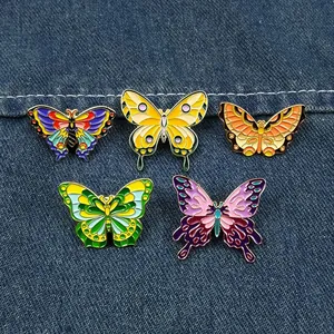 Detailansicht von fünf verschiedenen bunten Schmetterlings-Pins auf blauem Denim.