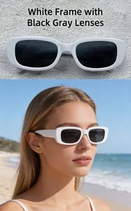 Detail view of retro white rectangle sunglasses with dark grey lenses on beach