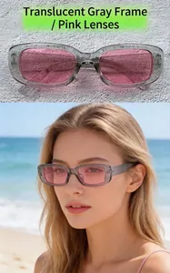 Model wearing vintage transparent grey frame sunglasses with pink lenses on a sunny beach