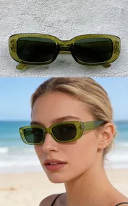 Detailed view of trendy green rectangle sunglasses on a model with a solo shot.