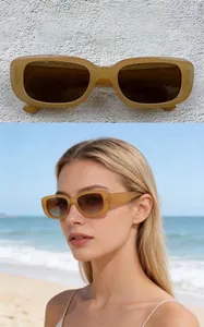 Detail view of retro jelly tea color rectangular sunglasses on a female model at the beach