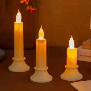 Vista ravvicinata di tre candele LED elettroniche senza fiamma su un tavolo