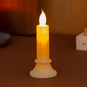 Vista dettagliata della calda fiamma luminosa su una candela elettronica a LED simulata