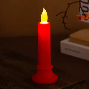Primo piano di una candela LED rossa senza fiamma con luce gialla per decorazioni