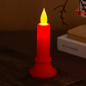 Candela LED rossa tremolante realistica su tavolo in legno per decorazioni festive