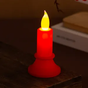 Candela LED elettronica senza fiamma rossa che brilla su un tavolo di legno scuro