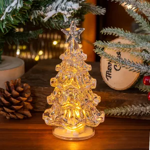 Detailed shot of a glowing mini acrylic Christmas tree on a warm wooden tabletop
