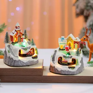 Detailed view of two snowy mountain Christmas music boxes with rotating trains and LED lights.