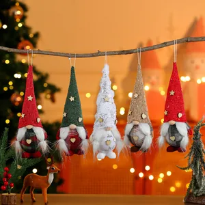 Detailed view of five festive Christmas gnome ornaments hanging from a natural branch.