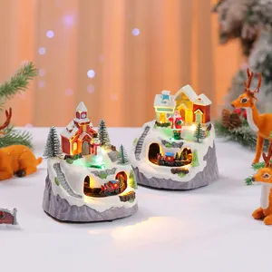 Detailed view of two glowing Christmas music boxes with rotating trains and snowy mountain design