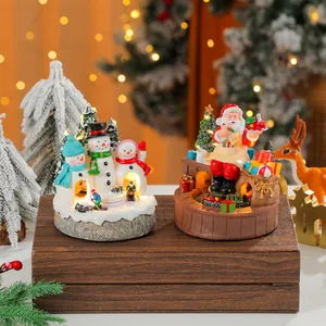 Detailed view of rotating Christmas resin music boxes with lights and Santa motifs