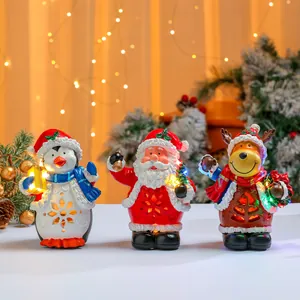 Set mit drei leuchtenden Weihnachtsfiguren aus Harz: Weihnachtsmann, Pinguin und Rentier