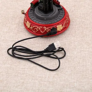 Close-up detail of black USB power cable connected to red musical Christmas ornament base