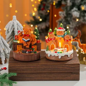 Detailed view of rotating glowing resin Christmas music boxes with bear and gingerbread designs