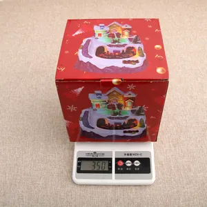 Christmas musical revolving house music box on digital scale showing 350g weight